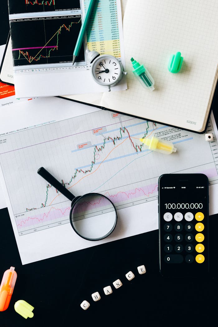 Home Stock market analysis setup with graphs, calculator, and magnifying glass.