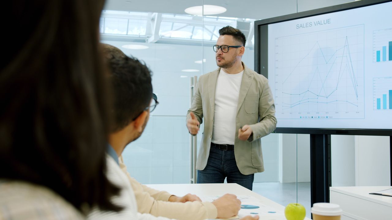 about-us Business presentation with charts discussing sales growth in conference room.